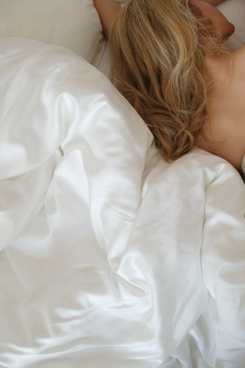 NUS Double sengetøj i hvid TENCEL™ Lyocell – kvinde sover i blødt dansk designet sengesæt